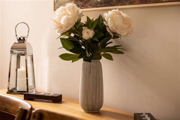 Vase of flowers and lantern with candle.